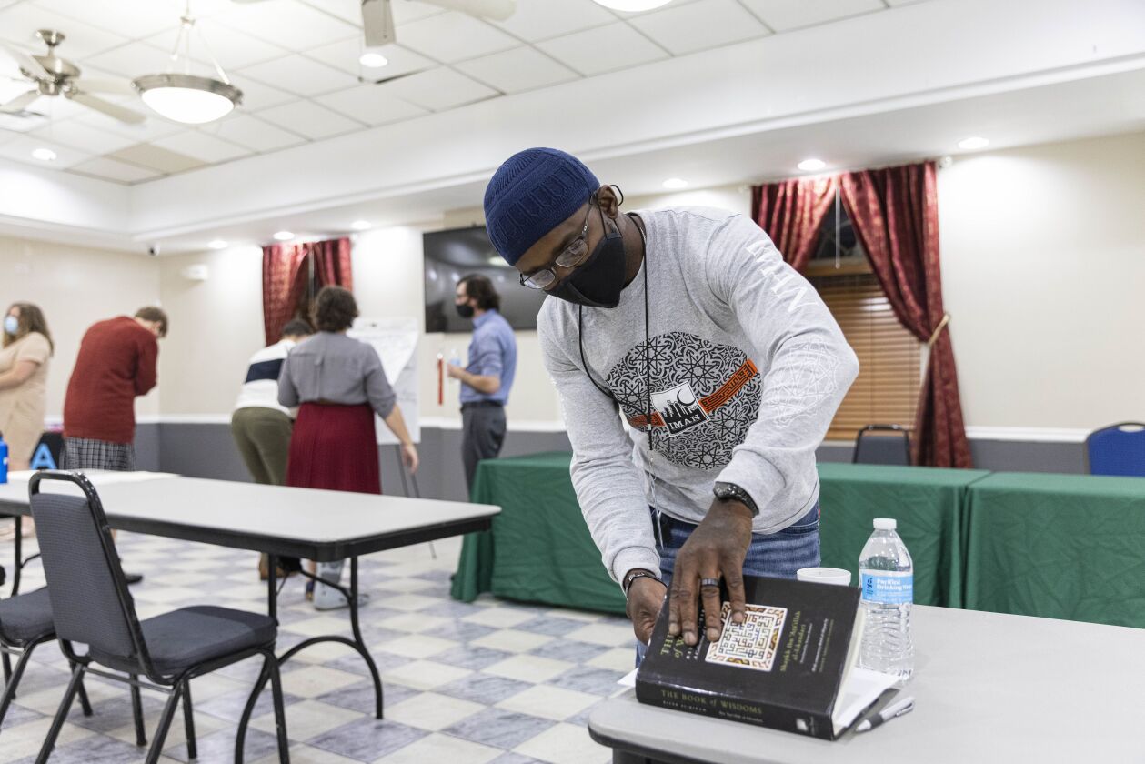 Amiin Davis picks up his book during a public forum Thursday in Old Irving Park.